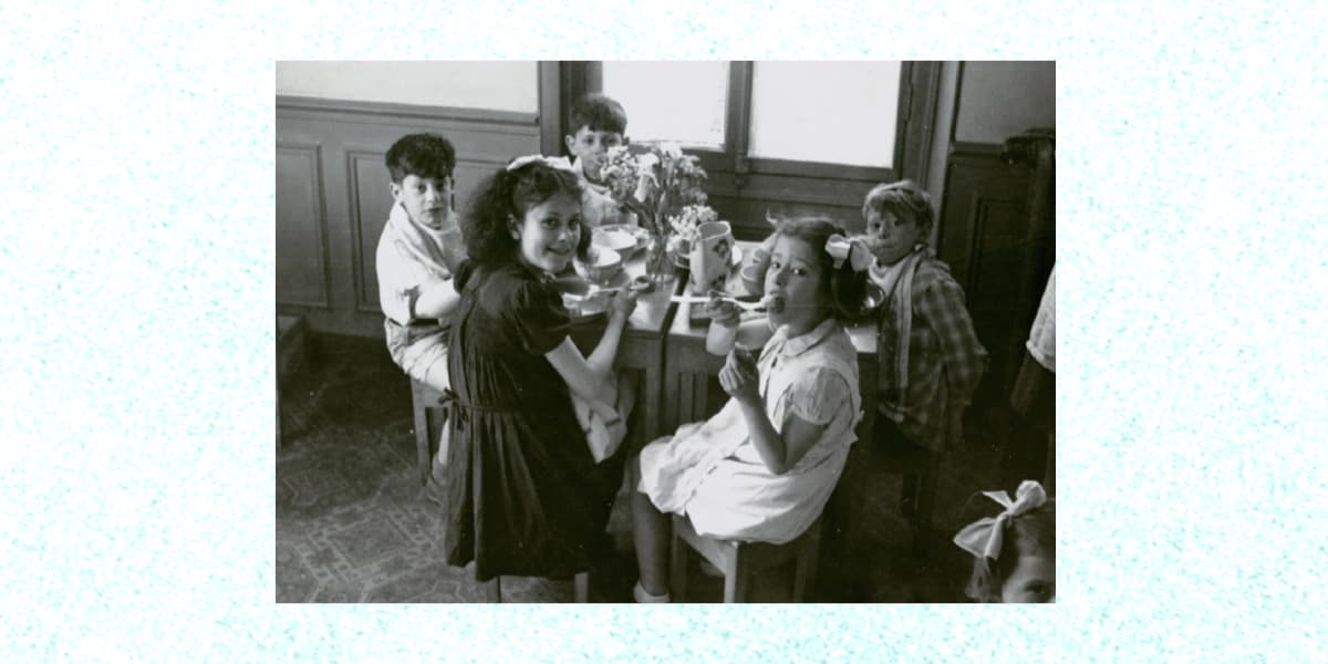 A group of children sitting around a small table and eating together in a children's home supported by JDC. Working in conjunction with OSE, JDC funded 61 children’s homes scattered across France, supporting approximately 15,000 Jewish children of all nationalities.