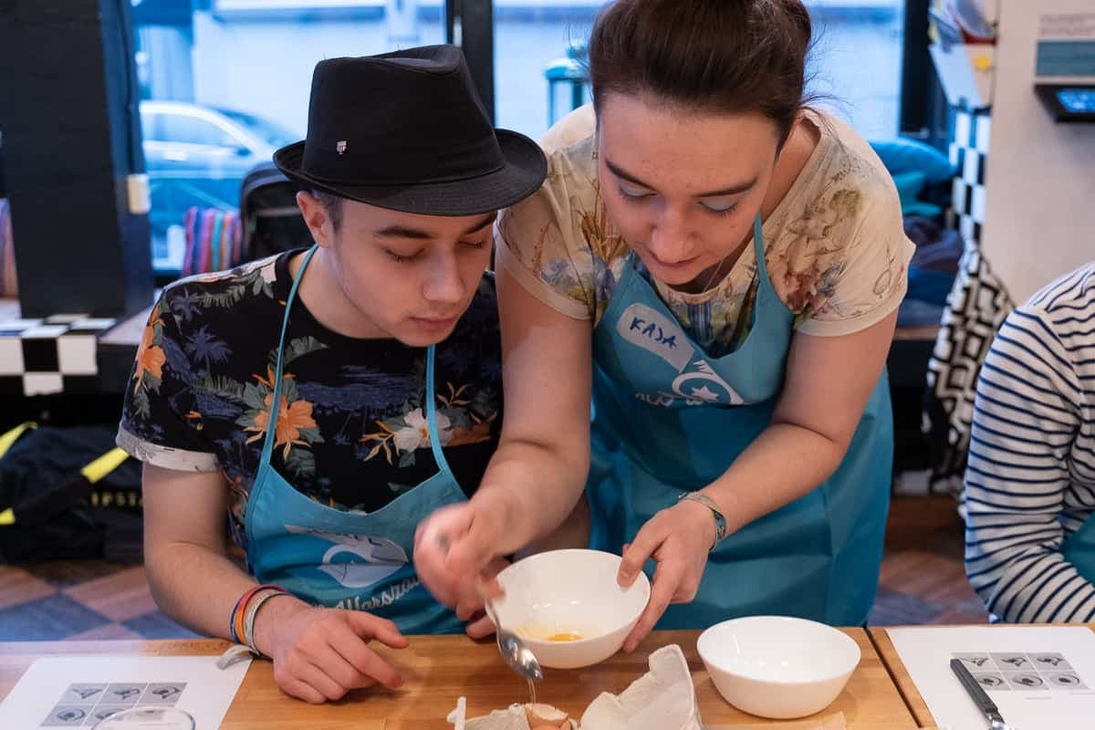 Kaja Siczek, right, assists a Polish Jewish teen at a JCC Warsaw cooking event.